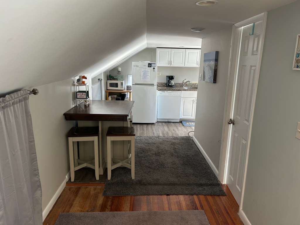 Hall with dining area and view of the kitchen.