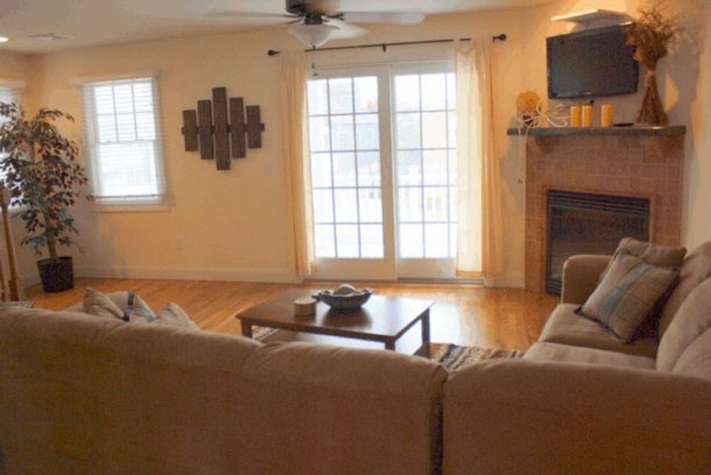 Open Living Room With Sliders To Outdoor Covered Deck With EatingTable and Chairs