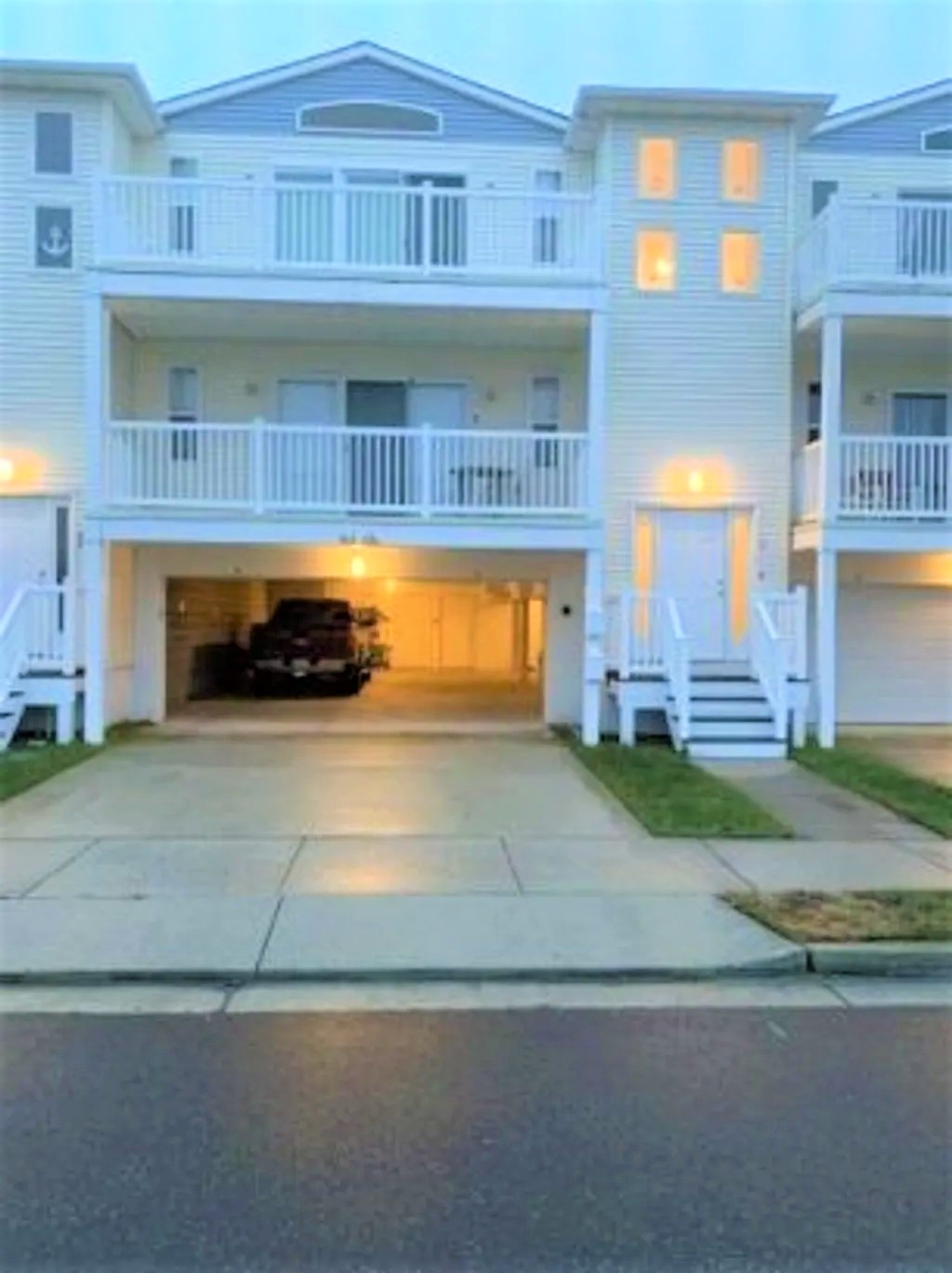 Front of building? Stairs to the right of the garage 