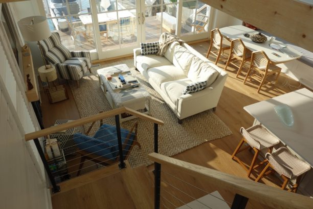 TV, sitting, and dining areas seen from stairs.  The long cushioned dining bench makes a nice extra sofa or reading nook.