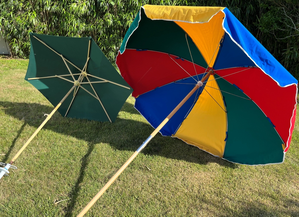two options for beach umbrellas - the green is lighter weight, but does not cover as much, The multicolored one is heavier, but provides more coverage