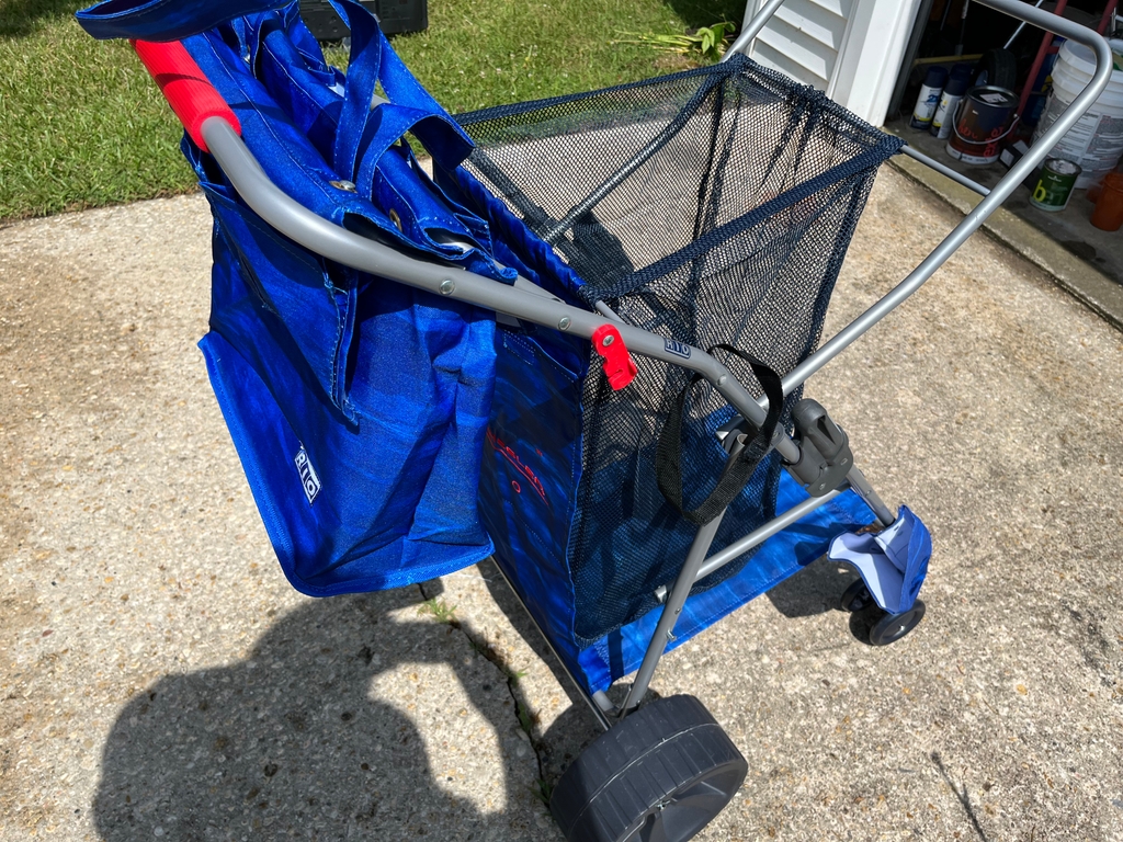 Beach caddy holds cooler, towels, snacks and at least 4 chairs.  Umbreallt also can be strapped to side
