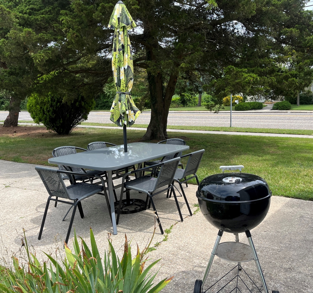 Outdoor table, six chairs and a charcoal grill with umbrella - enjoy dining outside if you wish